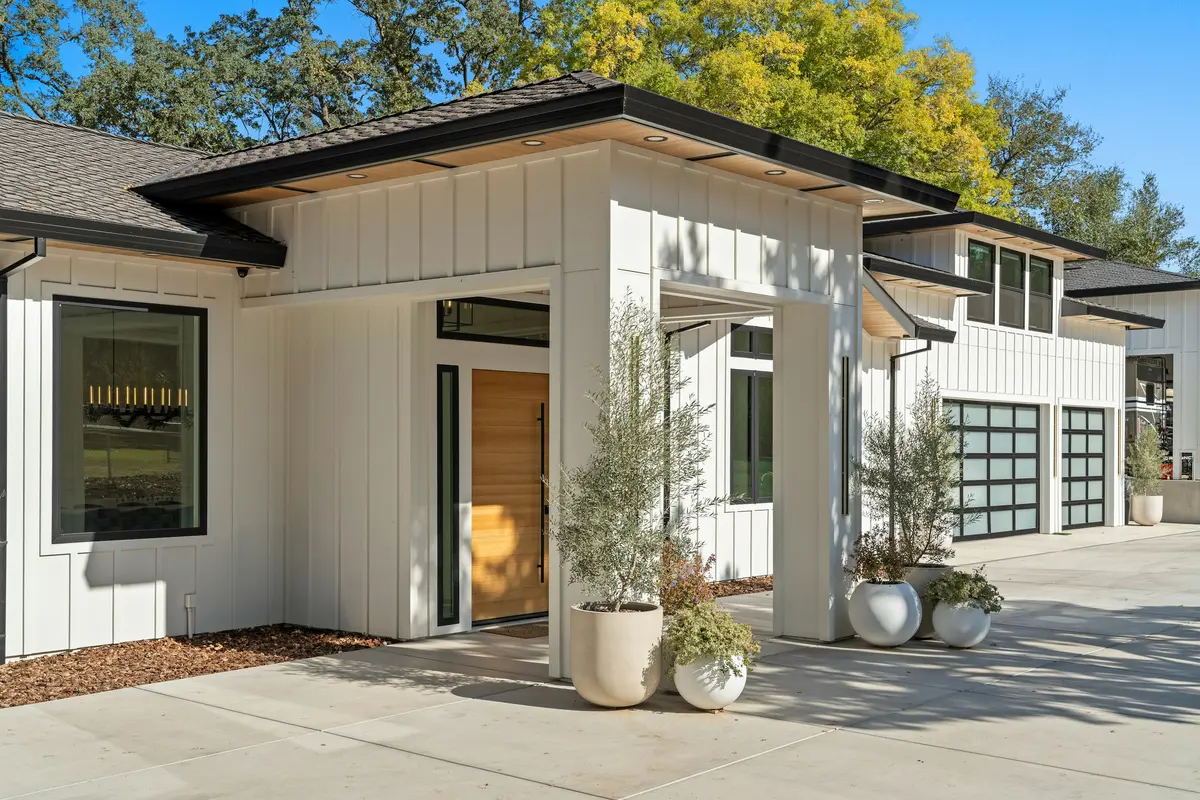 Architectural inspiration: contemporary white house with black roof trim, a wood front door and large windows